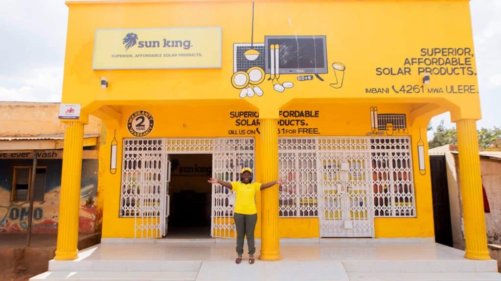 Sun King employee stands outside a Sun King store with her arms outstretched.